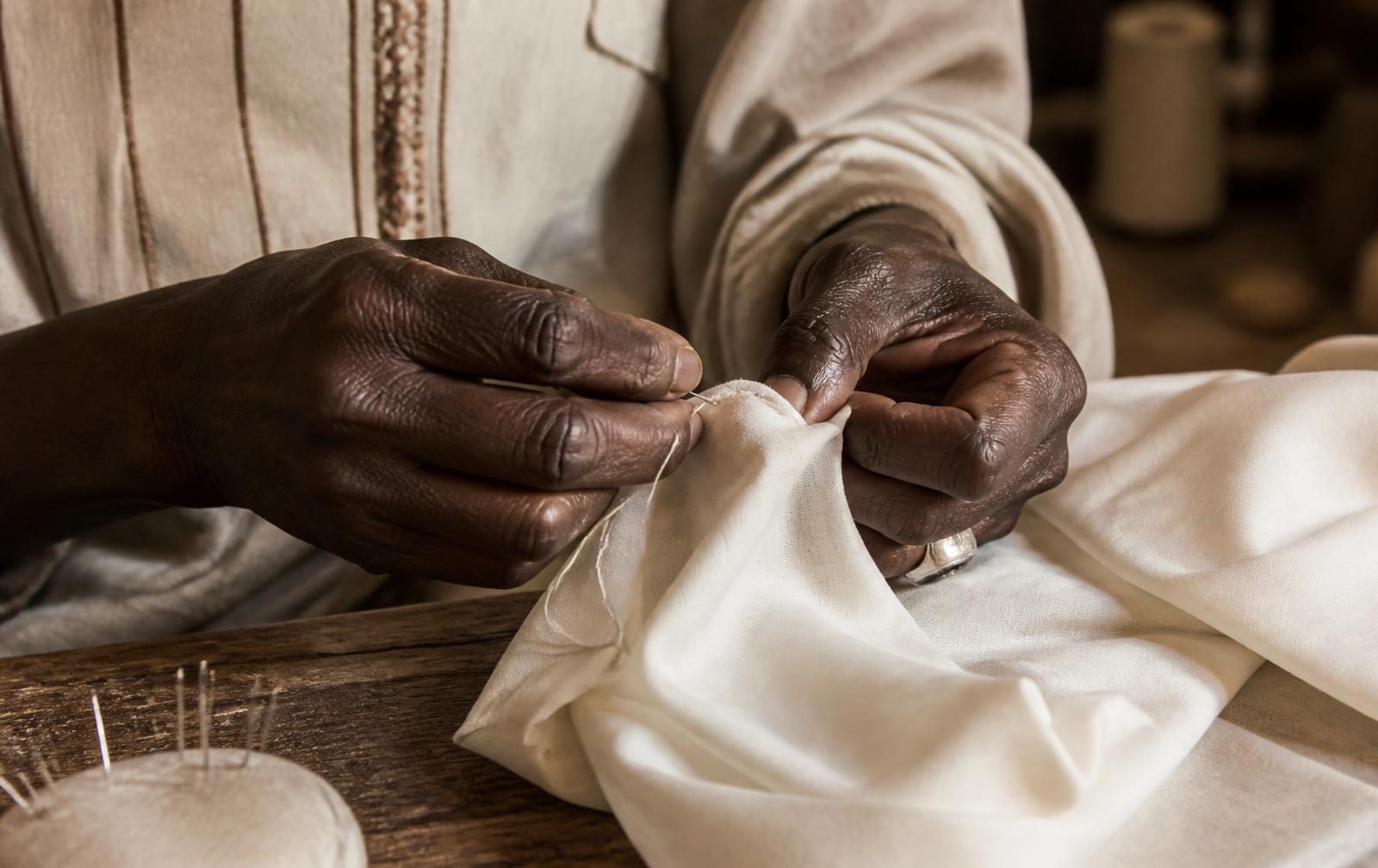 Artisan hand-stitching ivory silk in the Mossane atelier